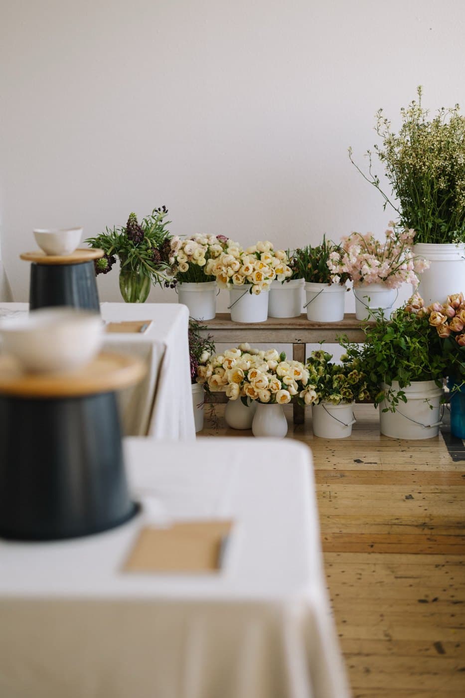 Buckets of ranunculus, tulips, sweet peas and hellebores set up for a private corporate flower workshop in Vancouver