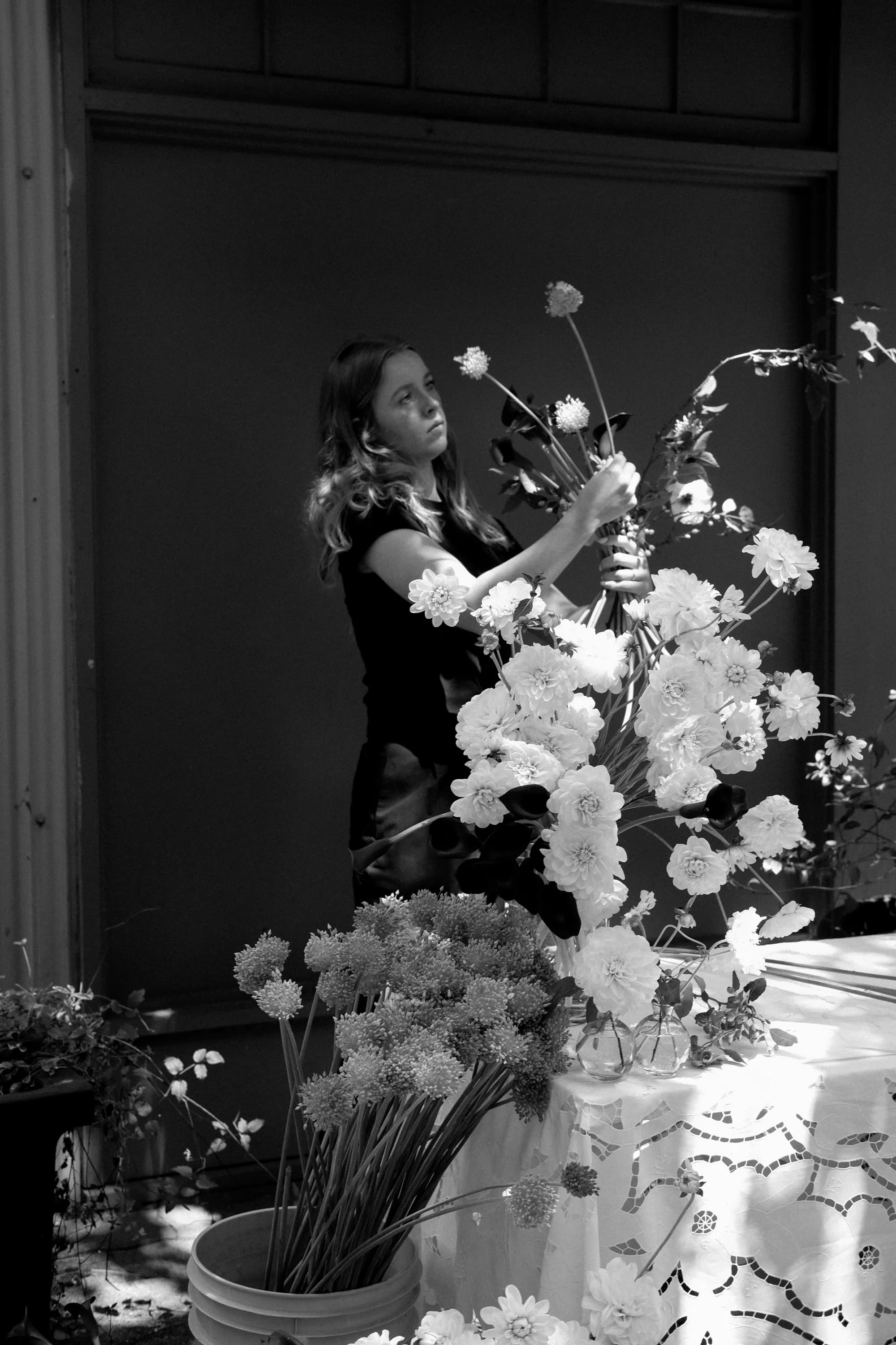 Bloomiér florist arranging elegant white flowers for a design-show installation